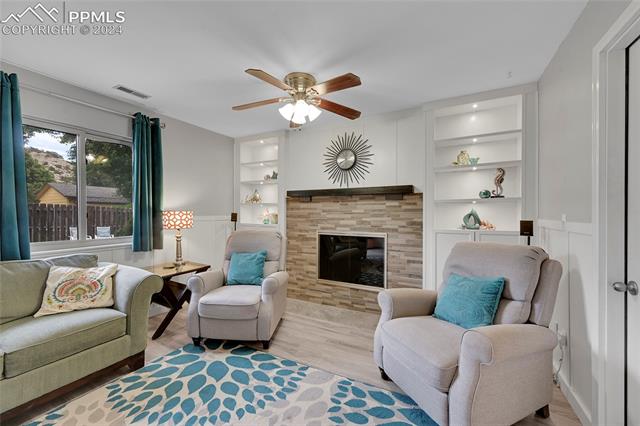 5255 Pinon Valley Road Colorado Springs, CO 80919 - Photo 15 of 47 Living room with built in features, light wood-type flooring, and ceiling fan