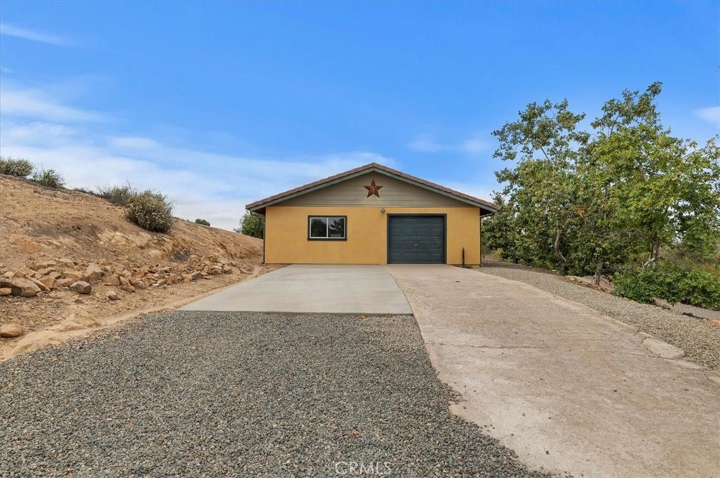 16420 Rocky Glen Road Perris, CA 92570 - Photo 59 of 74 a front view of a house with a yard and garage