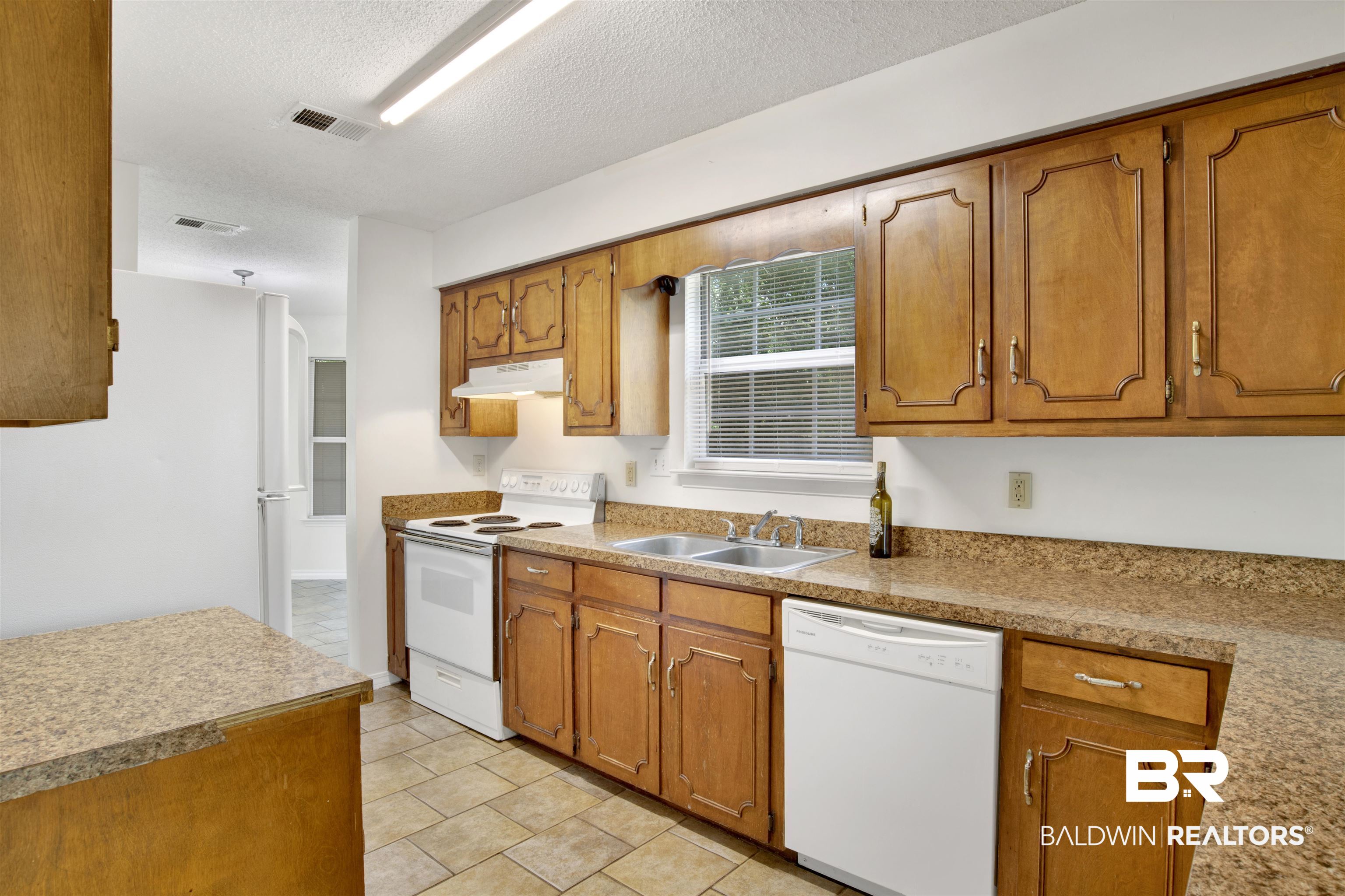 5480 Country Club Boulevard Theodore, AL 36582 - Photo 12 of 36 Kitchen featuring a textured ceiling, sink, and white appliances