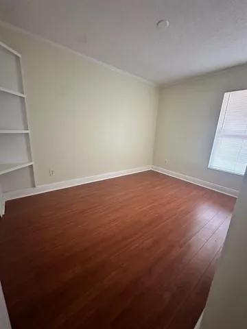 an empty room with wooden floor and closet