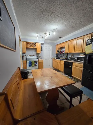 a large kitchen with a table chairs stainless steel appliances and cabinets