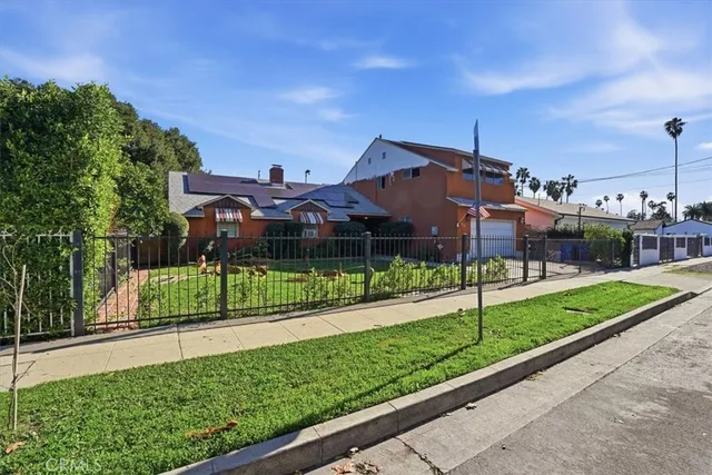 a front view of house with a yard and potted plants