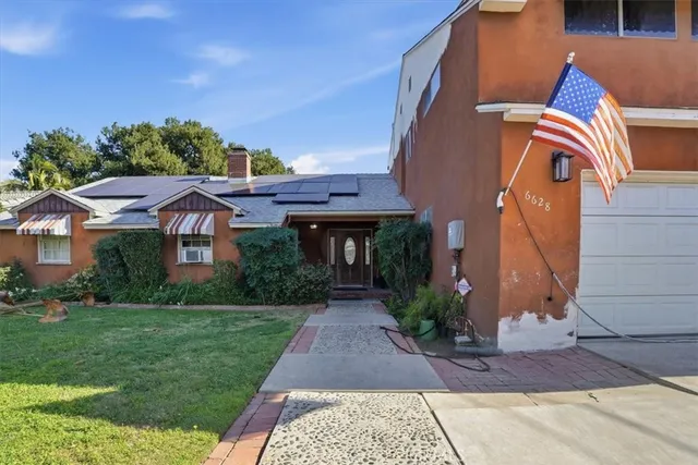 a view of a house with backyard and sitting area