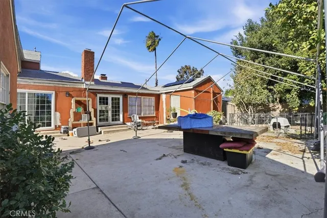 a view of a patio with couches and table and chairs with wooden fence