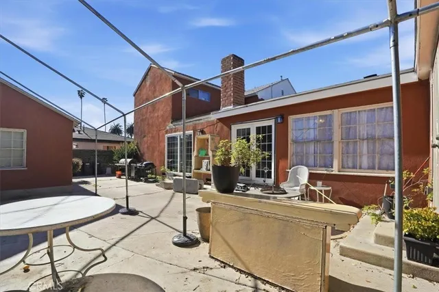 a view of a patio with table and chairs potted plants and a large tree