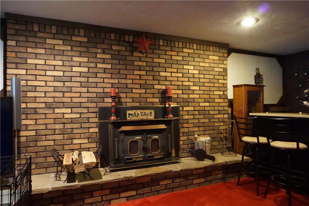 289 Hellein School Road Acme, PA 15610 - Photo 17 of 25 Wood Burning fireplace. Brick continues as half walls on each side.