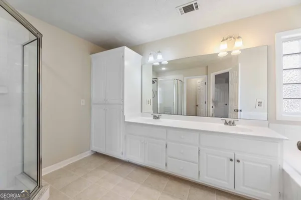 a bathroom with a double vanity sink and a mirror