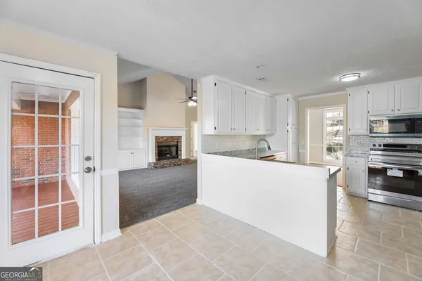 a kitchen with kitchen island granite countertop a stove top oven a sink and a refrigerator
