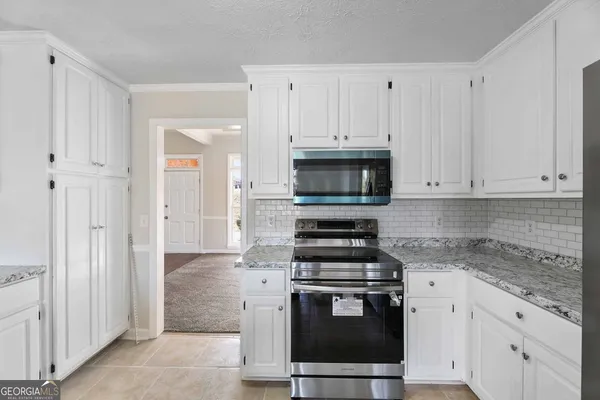a kitchen with white cabinets and stainless steel appliances