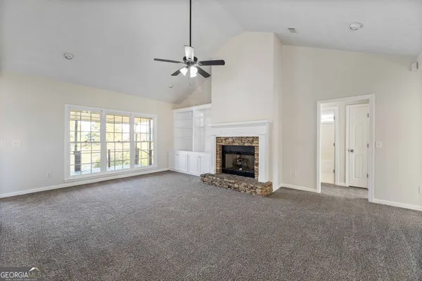 a view of empty room with a fireplace and fan