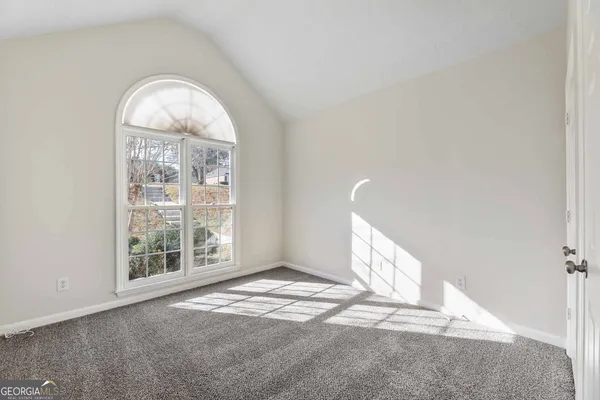 an empty room with a fireplace and windows