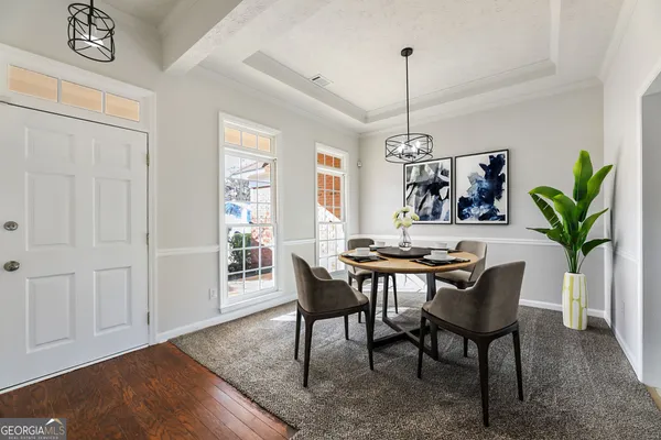 a dining room with furniture potted plants and wooden floor