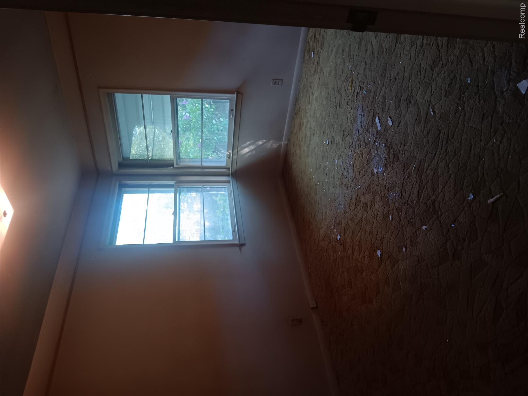 967 Washington Road Grosse Pointe, MI 48230 - Photo 12 of 15 Empty room featuring baseboards and dark carpet