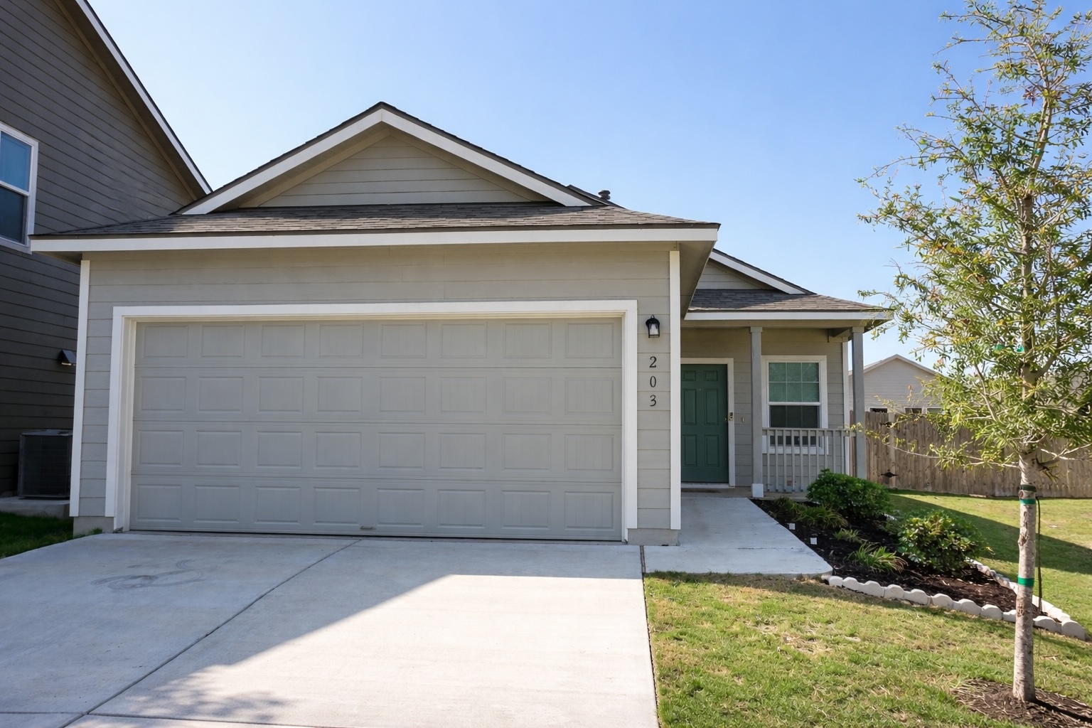 Single story home with a garage, a porch, concrete driveway, and roof with shingles