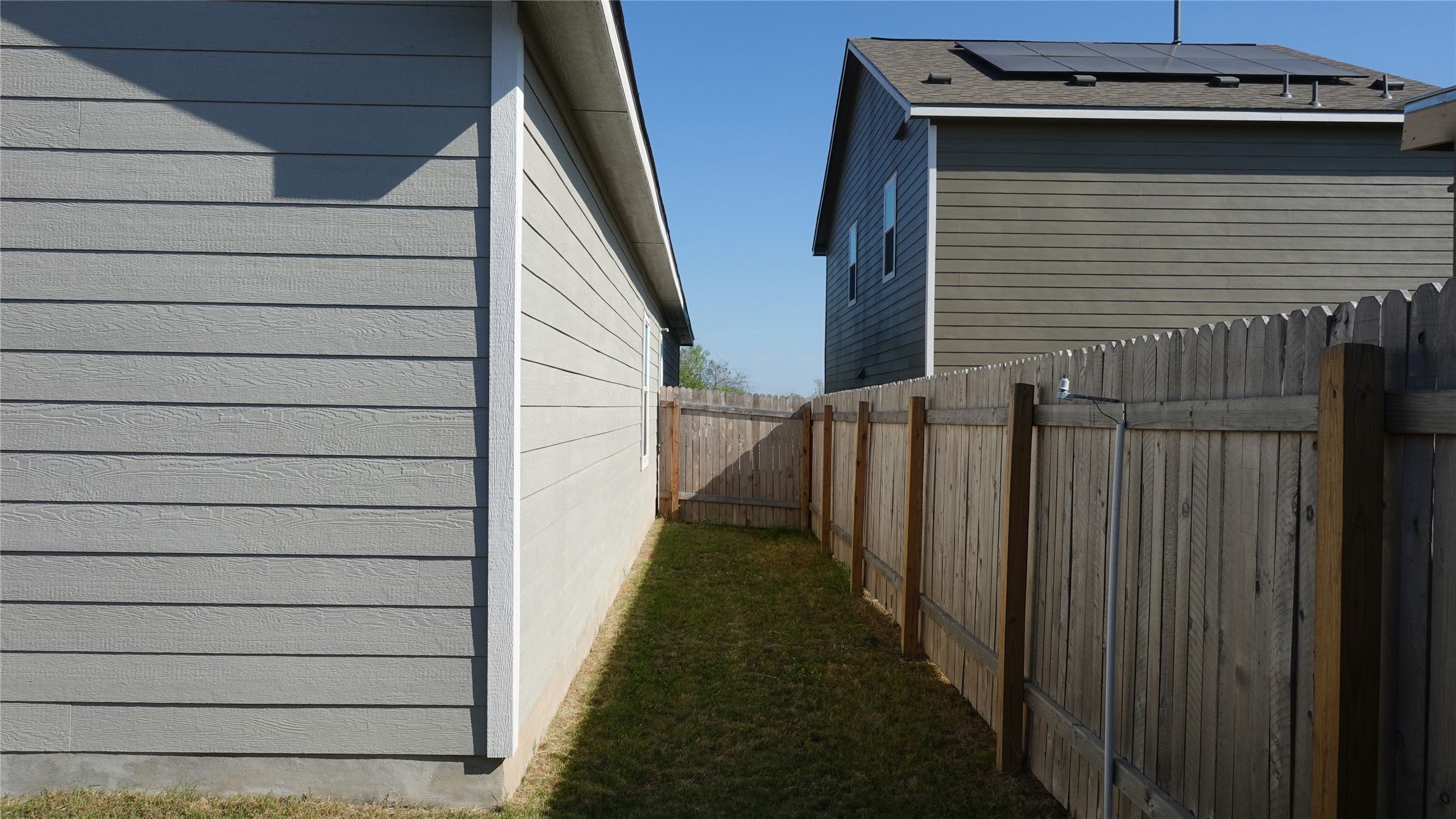 203 Tufted Duck Path Kyle, TX 78640 - Photo 17 of 19 View of side of property featuring roof mounted solar panels and a fenced backyard