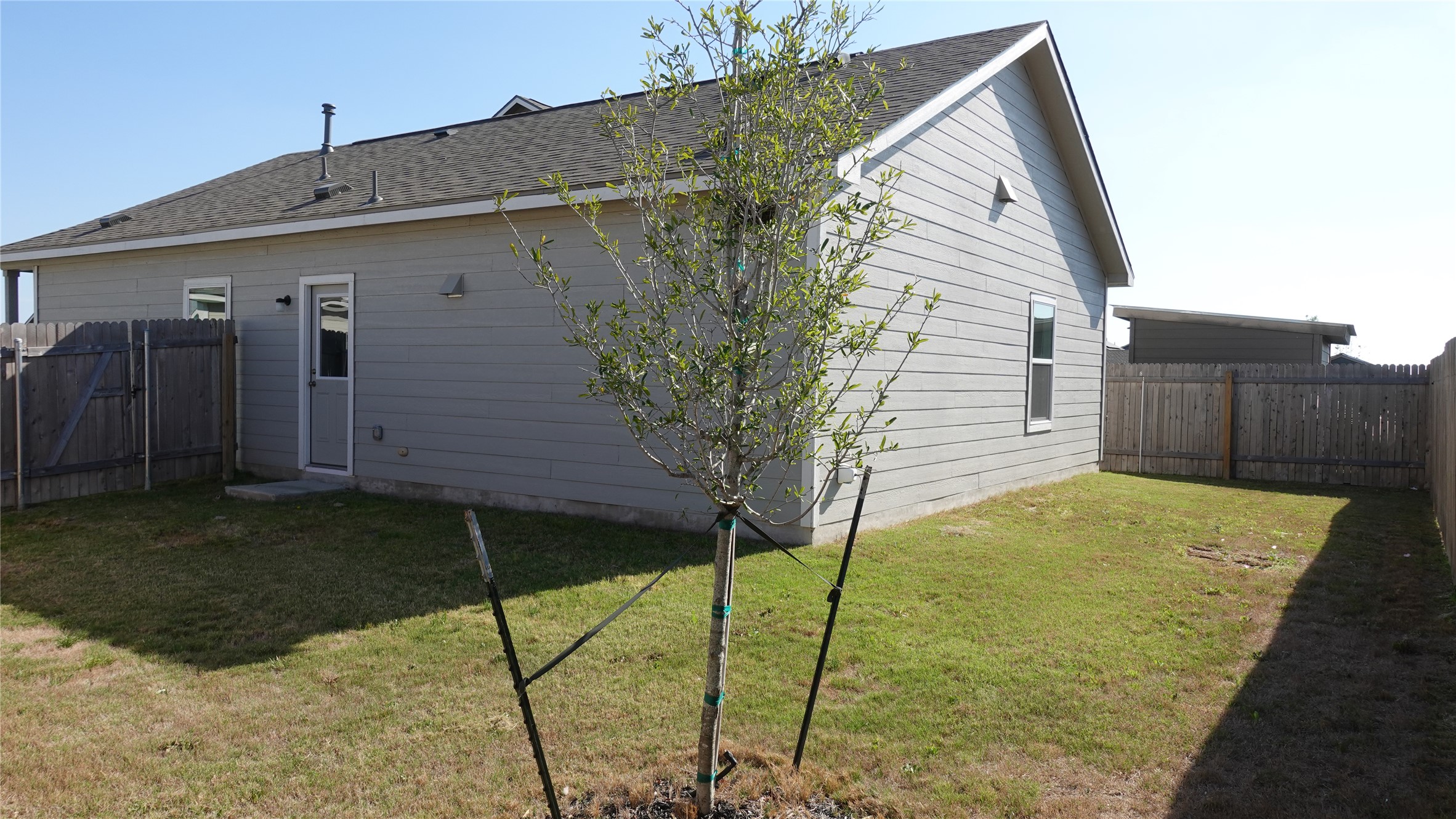 203 Tufted Duck Path Kyle, TX 78640 - Photo 19 of 19 View of side of property with a fenced backyard and a shingled roof