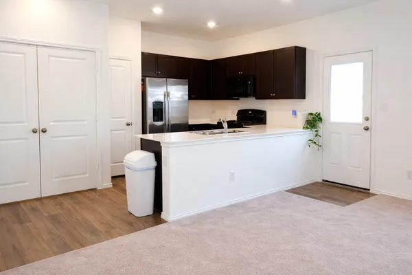 a kitchen with stainless steel appliances a refrigerator sink and white cabinets