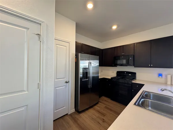a kitchen with a refrigerator stove and wooden cabinets