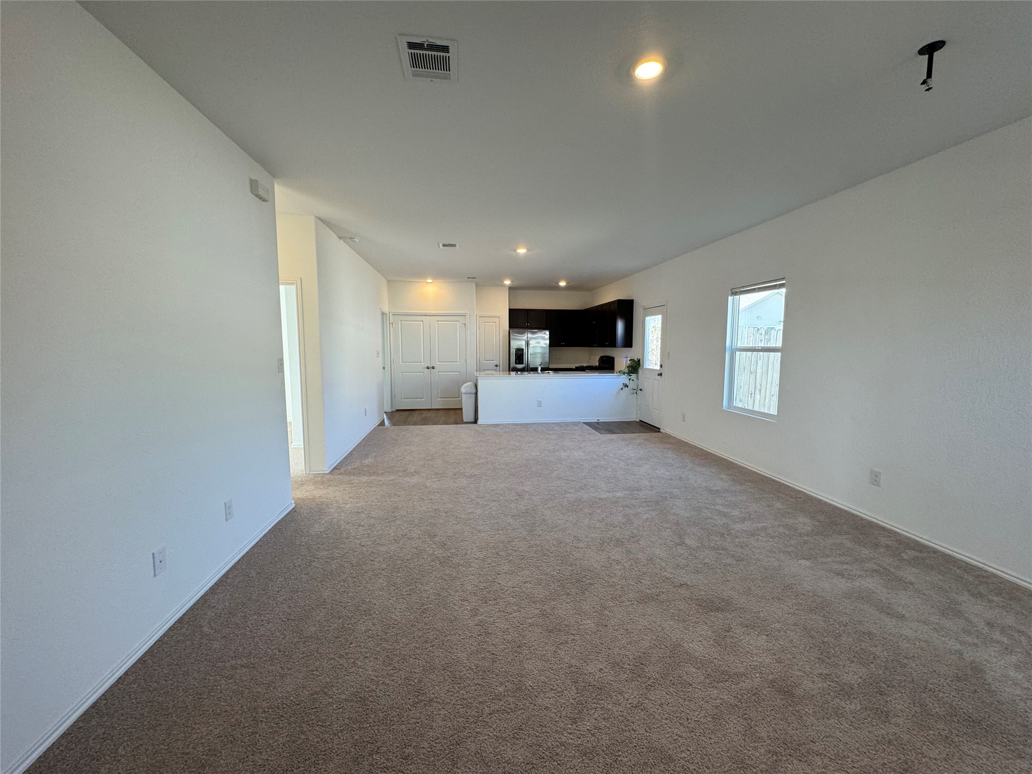 203 Tufted Duck Path Kyle, TX 78640 - Photo 6 of 19 Unfurnished living room featuring recessed lighting and dark colored carpet