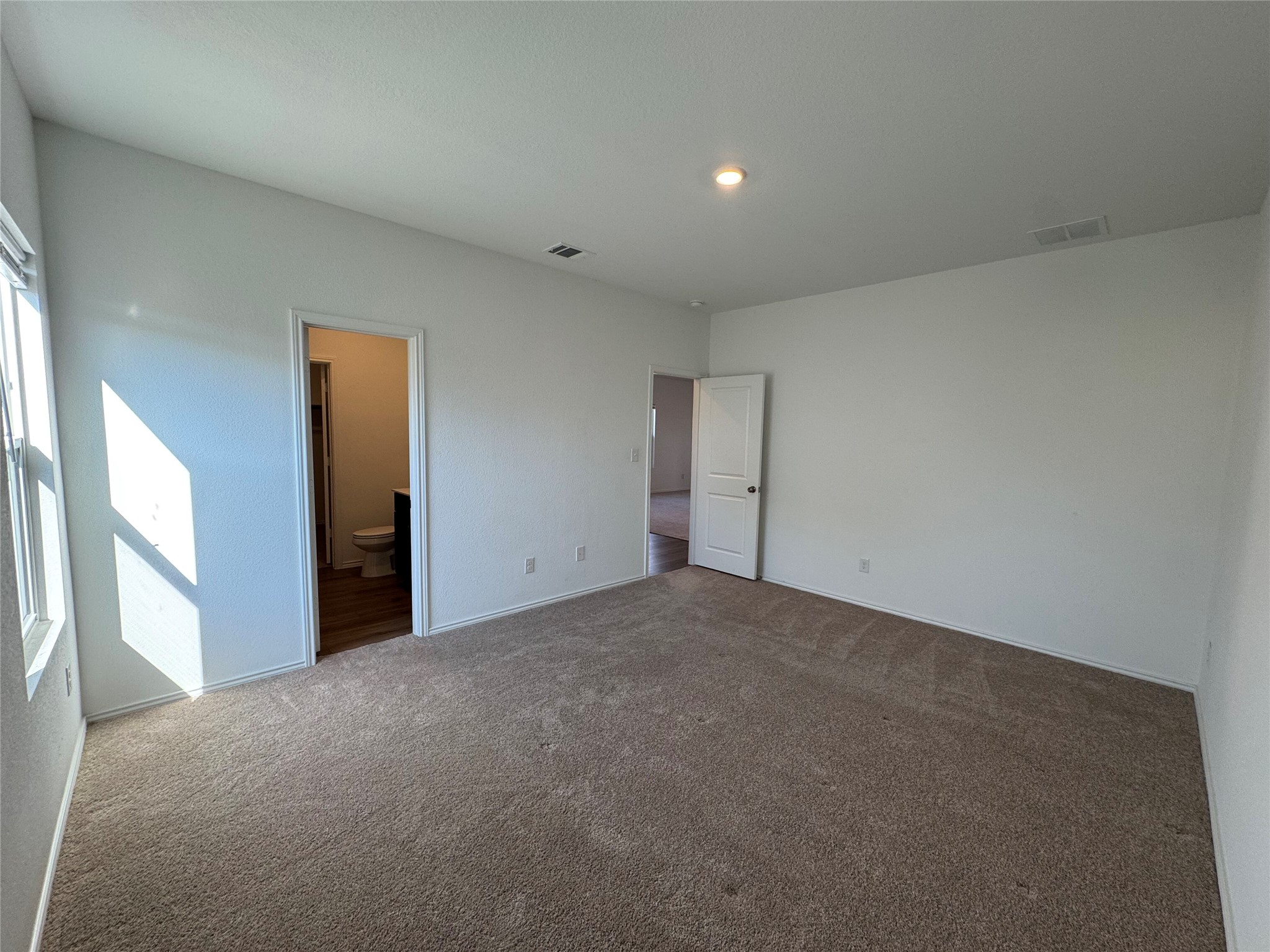 203 Tufted Duck Path Kyle, TX 78640 - Photo 8 of 19 Unfurnished bedroom featuring dark colored carpet and ensuite bathroom