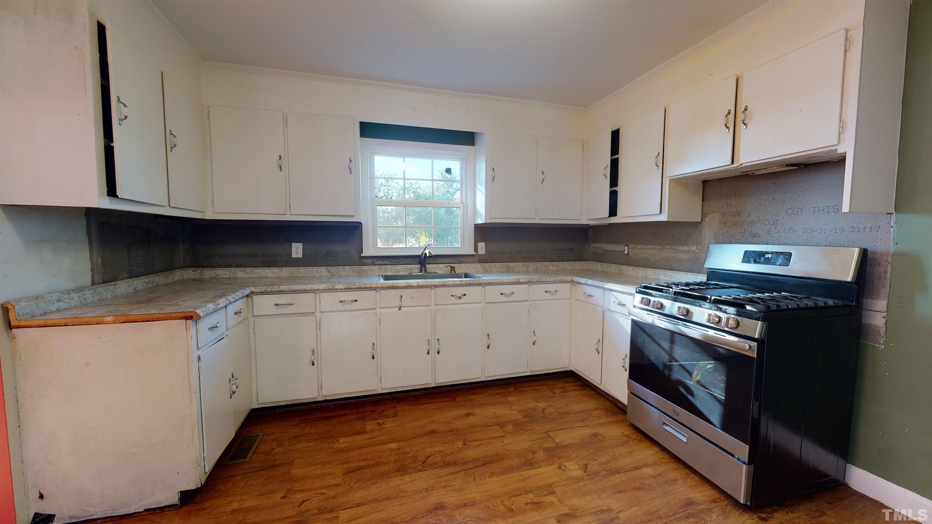 1306 Old Durham Road Roxboro, NC 27573 - Photo 16 of 28 a kitchen with granite countertop white cabinets and stainless steel appliances