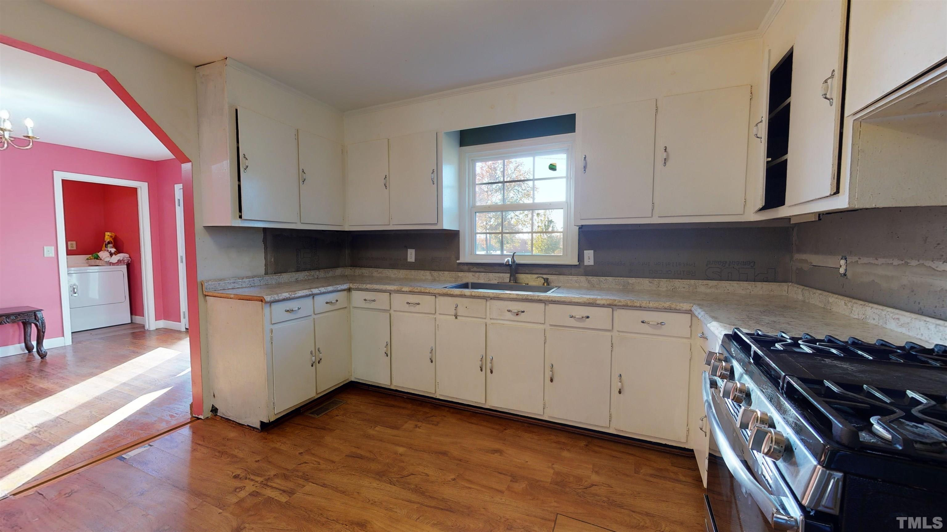 1306 Old Durham Road Roxboro, NC 27573 - Photo 17 of 28 a kitchen with granite countertop a stove a sink and dishwasher with white cabinets