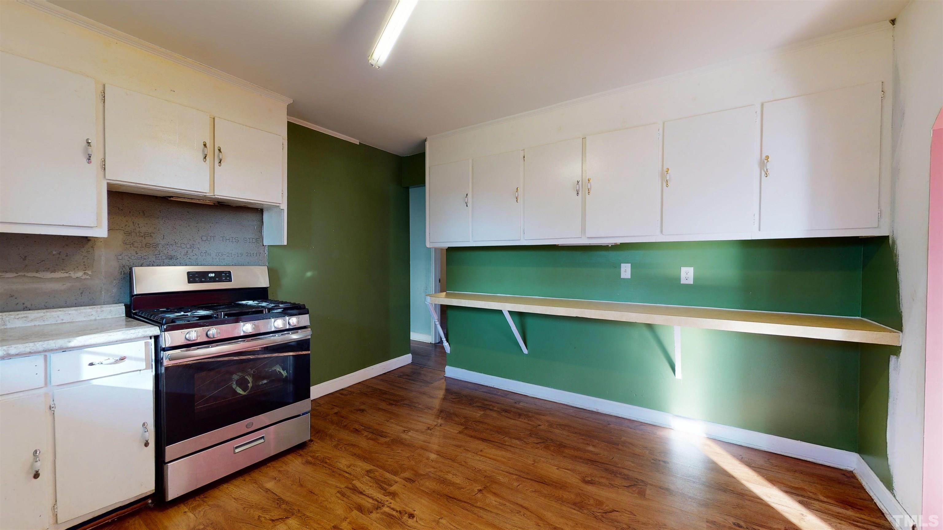 1306 Old Durham Road Roxboro, NC 27573 - Photo 18 of 28 a kitchen with green cabinets and a stove top oven