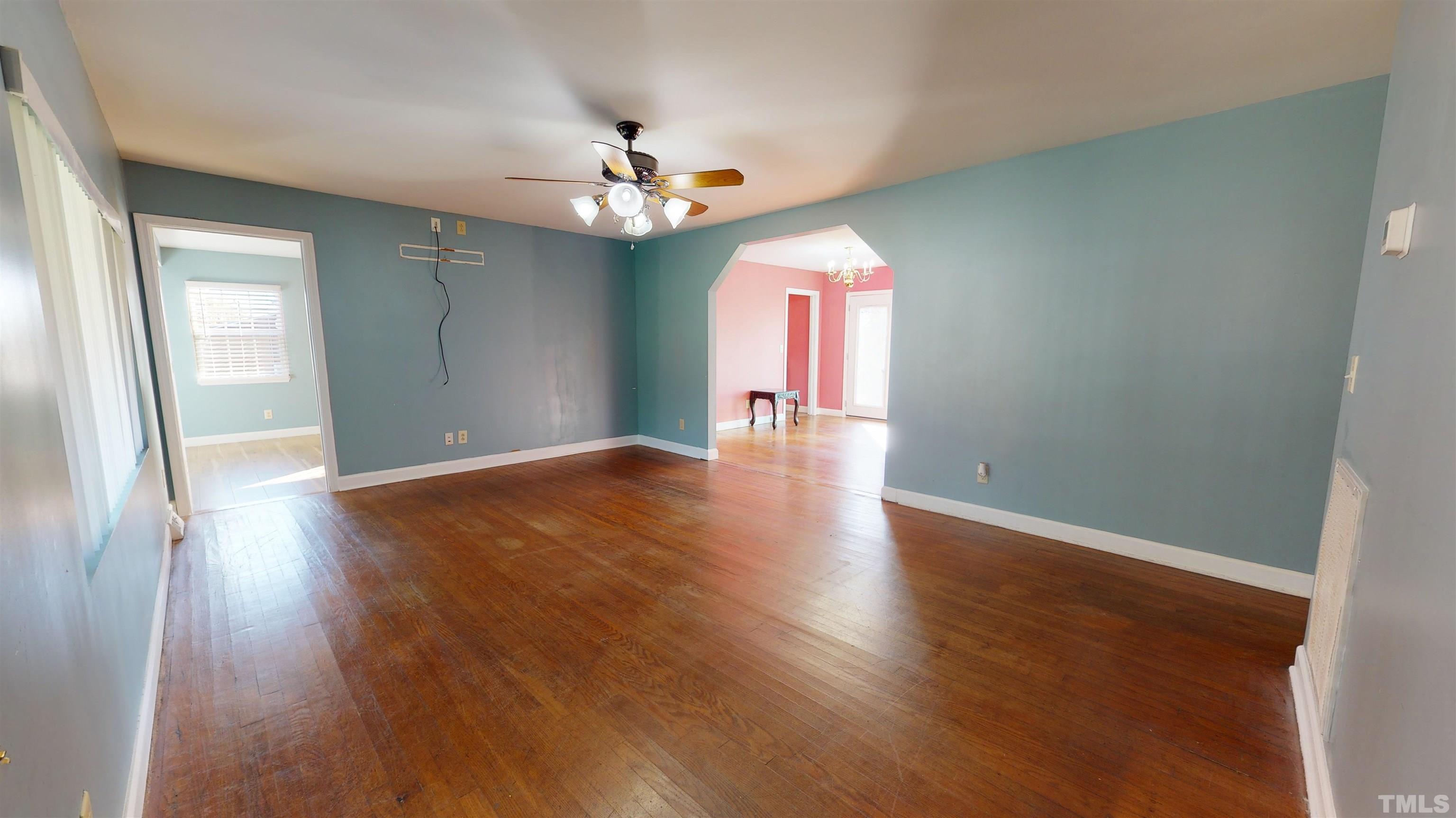 1306 Old Durham Road Roxboro, NC 27573 - Photo 8 of 28 an empty room with wooden floor and chandelier