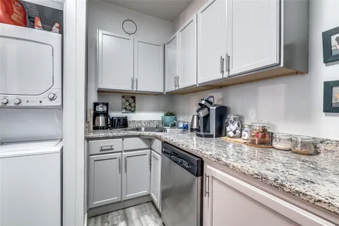 a kitchen with granite countertop white cabinets and white appliances