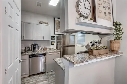a kitchen with stainless steel appliances granite countertop a sink and cabinets