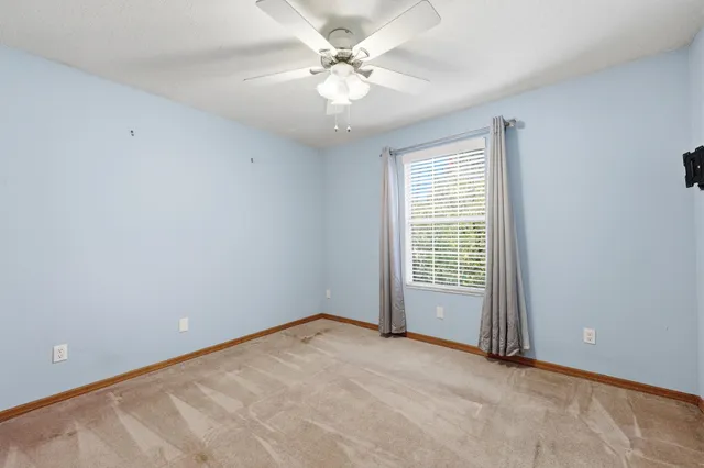 an empty room with chandelier fan