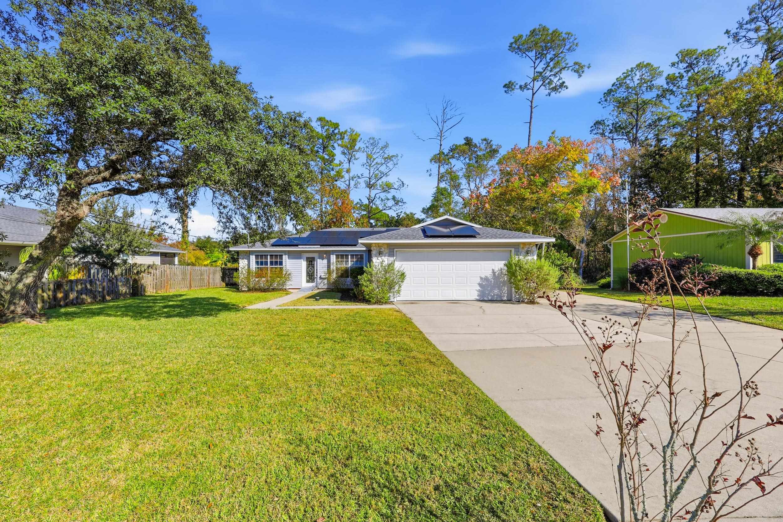 115 Segovia Road St. Augustine, FL 32086 - Photo 38 of 48 Ranch-style house with roof mounted solar panels, concrete driveway, and a garage