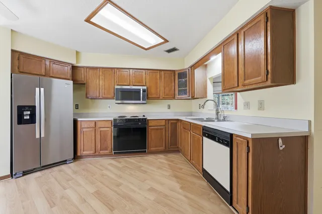 a kitchen with stainless steel appliances granite countertop a stove refrigerator sink and microwave