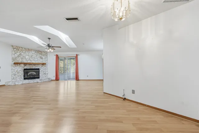 a view of an empty room with a fireplace and a window