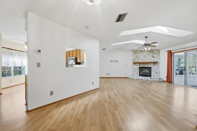an empty room with wooden floor fireplace and cabinet