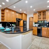 a kitchen with stainless steel appliances granite countertop a sink and a refrigerator
