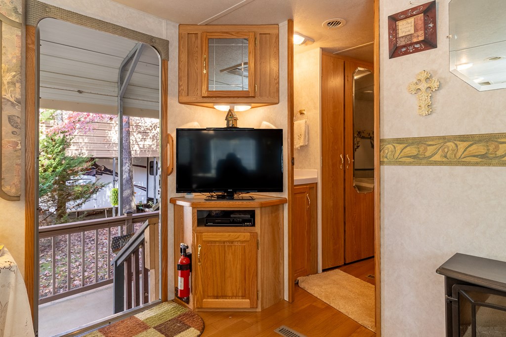 66-186 Peaceful Loop Chatsworth, GA 30705 - Photo 7 of 31 a living room with furniture a flat screen tv and a floor to ceiling window