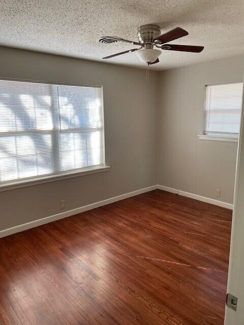 2409 Utica Avenue Lubbock, TX 79407 - Photo 12 of 22 an empty room with wooden floor fan and windows