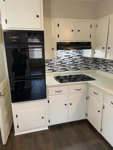 a bathroom with a granite countertop toilet a sink and mirror