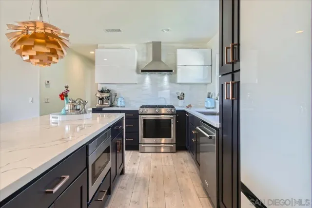 a kitchen with stainless steel appliances granite countertop a sink and a stove top oven