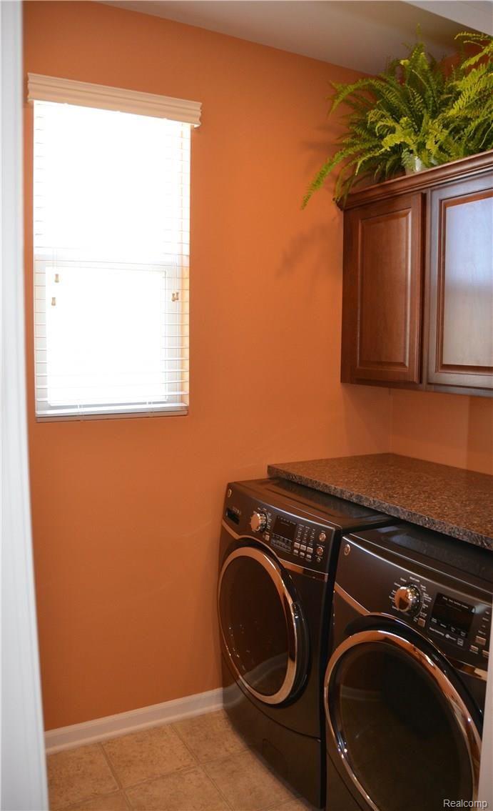 7026 Oakhurst Ridge Road Clarkston, MI 48348 - Photo 26 of 30 1st Floor Laundry withundercounter washer/dryer/custom cabinets overhead.
