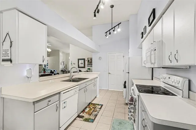a large white kitchen with a stove and a sink