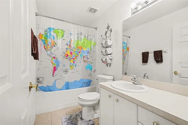 a bathroom with a sink a toilet and a shower curtain