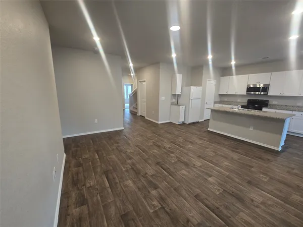 a view of a kitchen with cabinets and wooden floor