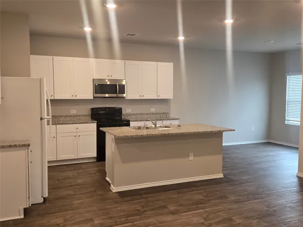 a view of kitchen with stainless steel appliances granite countertop a stove a sink and a refrigerator