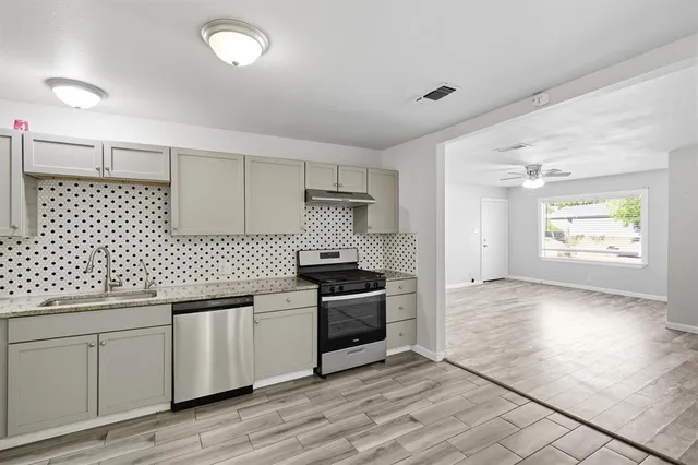 a kitchen with stainless steel appliances a stove a sink and a refrigerator