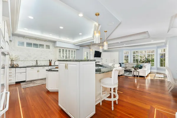 a living room with a large window and chandelier