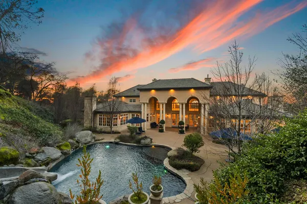 a view of a house with swimming pool and sitting area