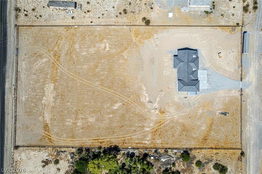 5910 East Kellogg Road Pahrump, NV 89061 - Photo 50 of 58 An aerial perspective showcases a substantial land parcel, featuring a newly constructed residence and vast open space.