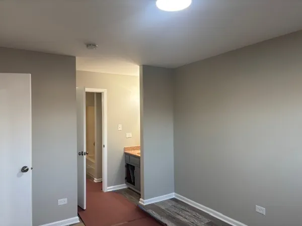 a view of a hallway with a room space and wooden floor